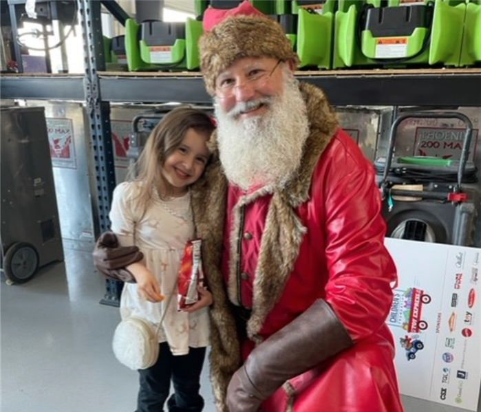 Little girl posing for photo with Santa. 